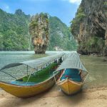 Spiaggia Thailandese immersa nella natura con barche tipiche del posto